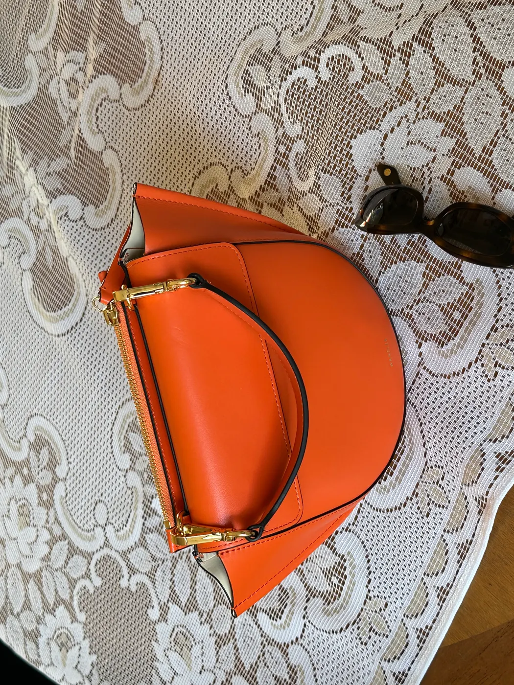 Orange handbag on lace tablecloth